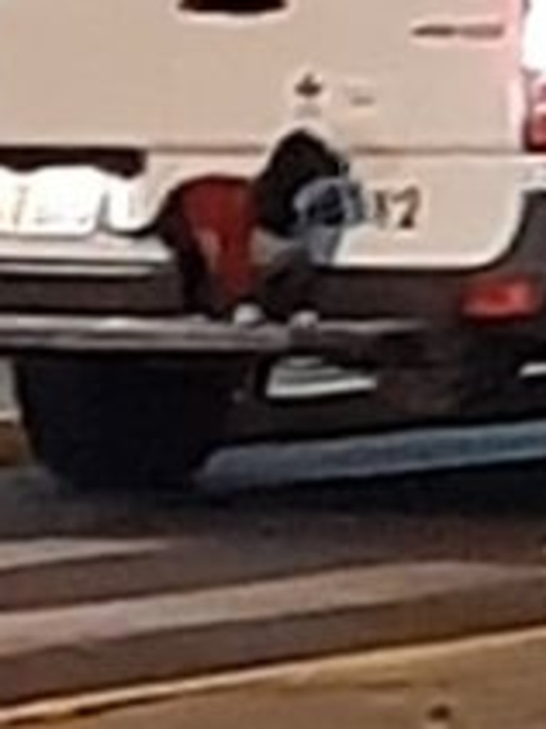 Here, the pooch sits on the rear bumper as the ambulance is about to drive off. Picture: Anderson Bahi/Facebook