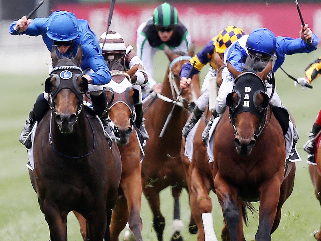 Demonstrate, ridden by James McDonald (all blue) holds off Sovereign Nation (Mark Zahra in blue and white) to win race 4. Picture : Michael Klein