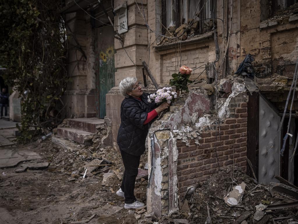 A woman arranges flowers outside a house where a couple was killed in a Russian drone strike. Picture: Getty Images