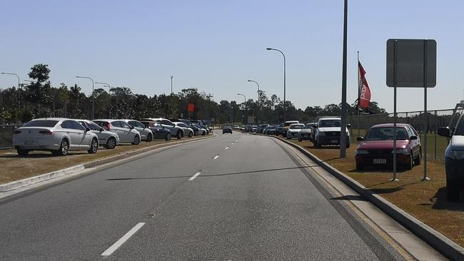 Cars parked on the grass verge on Country Club Drive outside Helensvale Train Station in August last year.