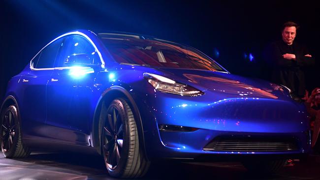 Tesla CEO Elon Musk walks beside the Tesla Model Y. (Photo by Frederic J. BROWN / AFP)