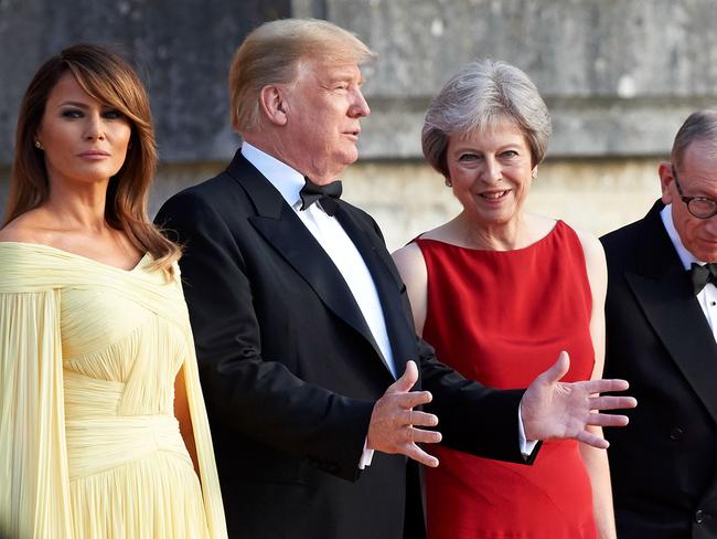 (L-R) US President Donald Trump, Britain's Prime Minister Theresa May, US First Lady Melania Trump and Philip May stand on the steps in the Great Court to watch the bands of the Scots, Irish and Welsh Guards perform a ceremonial welcome as they arrive for a black-tie dinner with business leaders at Blenheim Palace, west of London, on July 12, 2018, on the first day of President Trump's visit to the UK.  The four-day trip, which will include talks with Prime Minister Theresa May, tea with Queen Elizabeth II and a private weekend in Scotland, is set to be greeted by a leftist-organised mass protest in London on Friday. / AFP PHOTO / POOL AND AFP PHOTO / Niklas HALLE'N