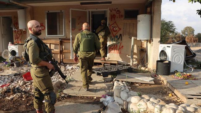 Israeli soldiers secure the area as volunteers search the homes and grounds in Kibbutz Kfar Aza in the aftermath of an attack by Palestinian militants on October 7. Picture: AFP