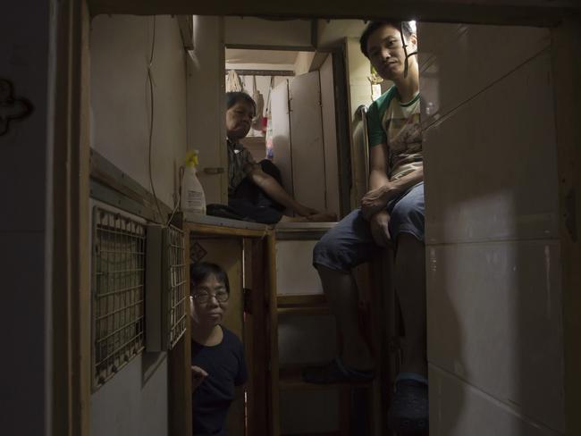 Hong Kong residents, who only gave their surname, Lam, top left, Wan, top right, and Kitty Au are seen sitting in their respective homes. Picture: Kin Cheung/AP