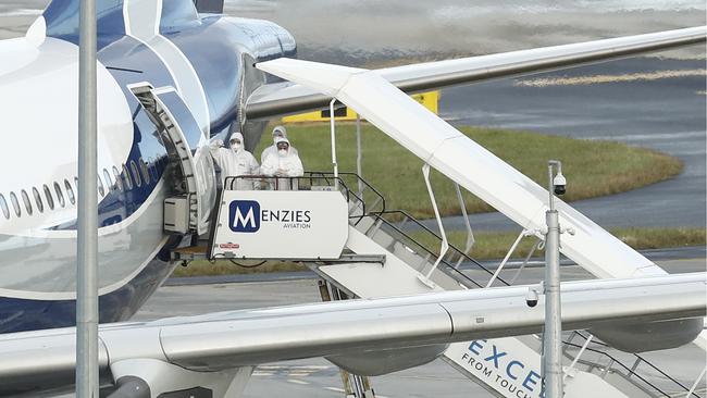 Crews in hazmat suits board the jet. Picture: Getty