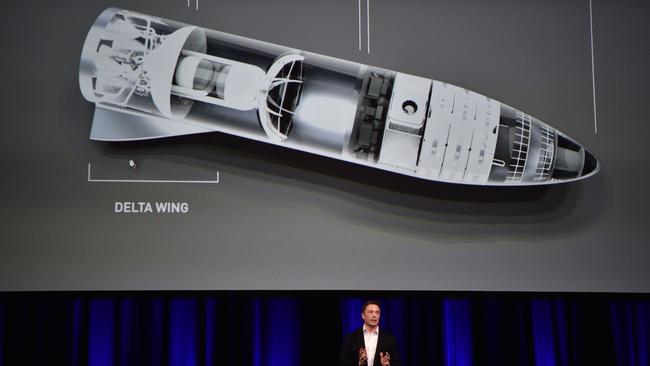 Elon Musk speaks in 2017 below a computer-generated illustration of his new rocket. Picture: AFP