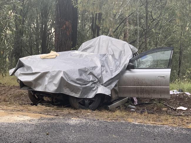 The vehicle, which collided with a tree on Pringles Way, Lawrence, is covered with a tarp to protect it from the rain prior to crash investigators arriving on scene.