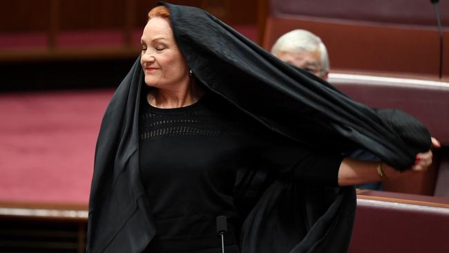 One Nation Senator Pauline Hanson takes off a burqa during Senate Question Time at Parliament House in Canberra, Thursday, August 17, 2017. Picture: AAP /Lukas Coch.