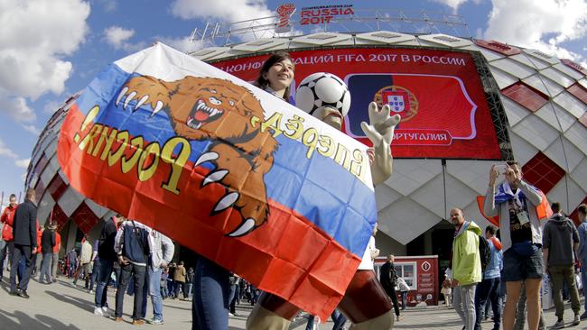 A Russian supporter poses for pictures outside the stadium, prior to the Confederations Cup match between Russia and Portugal.
