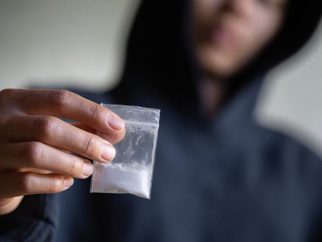 Hand of addict man holding cocaine or heroine, close up of addict buying dose from drug dealer, drug trafficking, crime, addiction and sale concept, istock image