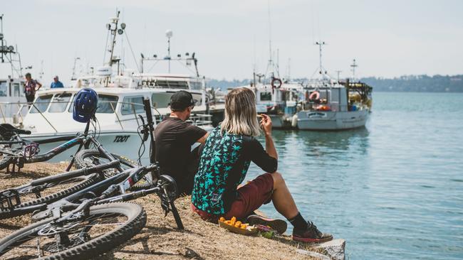 People eating fish and chips by the shore at St Helens, Tasmania. For TasWeekend summer edition. Picture: Stu Gibson