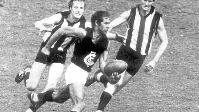 Carlton star Syd Jackson escapes the clutches of Collingwood’s Lee Adamson.