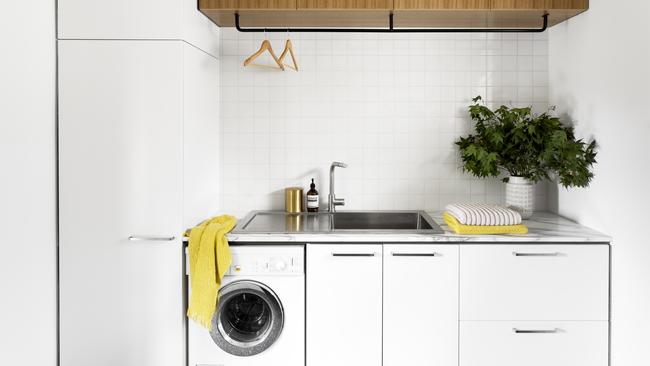 A double sink with removable lid plus a rack for hanging clothes are great space savers in a small laundry like this, designed by Cantilever Interiors