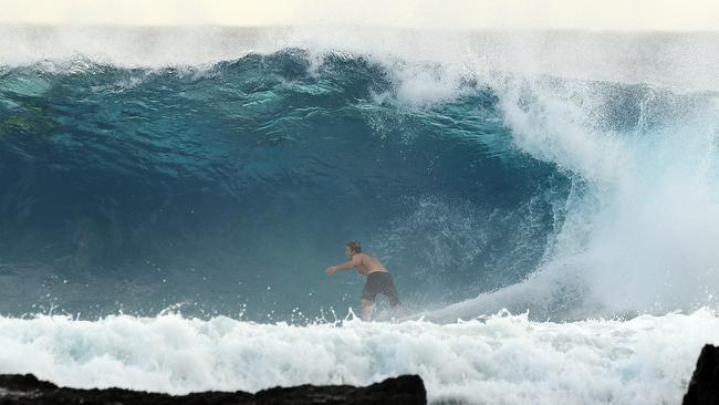 A surfer is seen at Snapper Rocks on the Gold Coast, Thursday February 21, 2019. Huge swells and high tides are set to pummelling southeast Queensland beaches over the coming days as Cyclone Oma tracks towards the Queensland coast. (AAP Image/Dave Hunt)