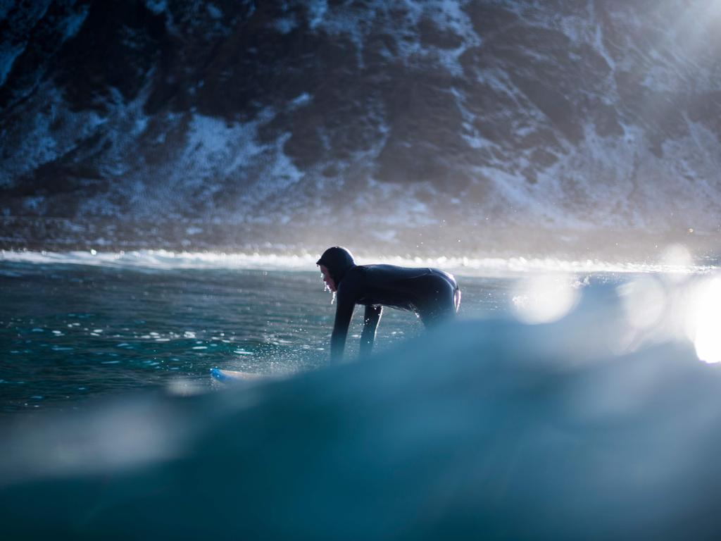 A surfer rides a wave on March 10, 2018 in Unstad, northern Norway, Lofoten islands, within the Arctic Circle as air temperature drops minus 13°C and water temperature above 4°C. Picture: AFP