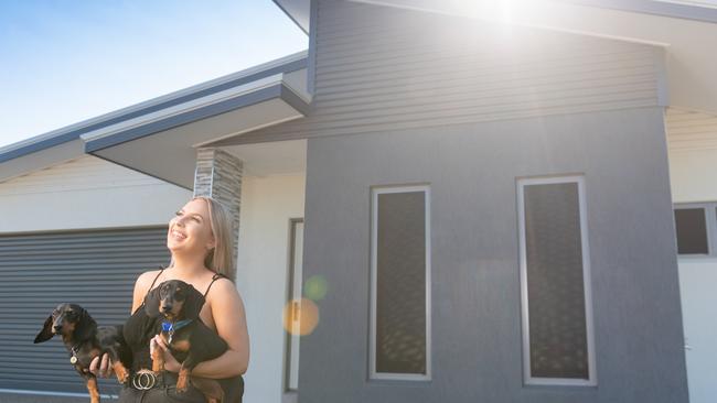 Kate Johnson, 21, was a beneficiary of the NT Government's Build Bonus program, buying her first house in Zuccoli, Darwin. She is pictured here with her two dogs Ollie and Bentley three weeks after moving in to her new home. Picture: Che Chorley