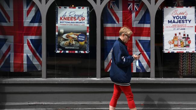 A pedestrian walks past Union flags hung in the windows of a pub in Colchester. Picture: AFP