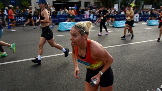 The leading female runner at the time grabs a gel in the ASICS Runaway Noosa Marathon. Photo: Mark Furler