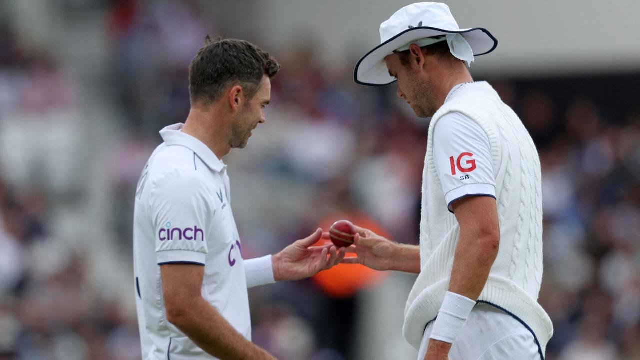 England's James Anderson (L) and England's Stuart Broad (R) examine the ball. (Photo by Adrian DENNIS / AFP)