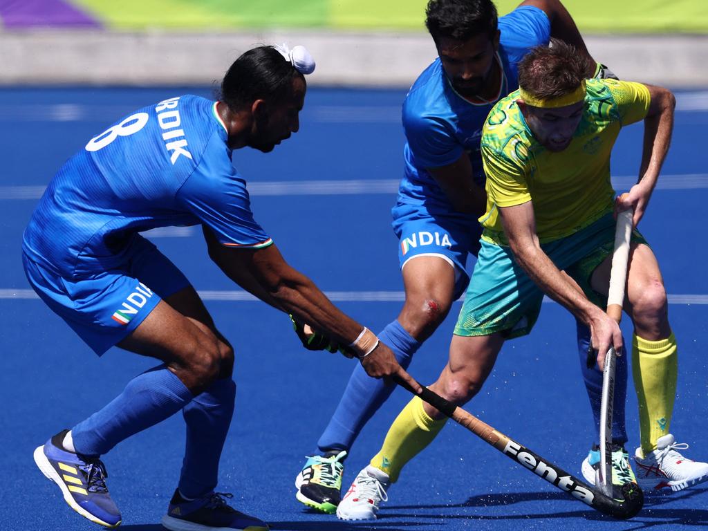 Australia's Nathan Ephraums competes against India's Abhishek and Singh Hardik during the men's gold medal hockey match. Picture: Darren Staples.