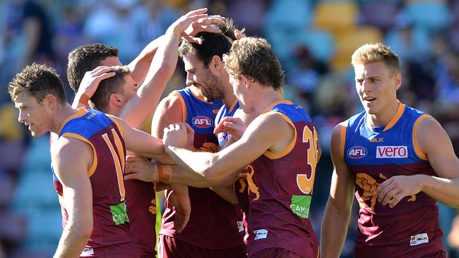 BRISBANE, AUSTRALIA — AUGUST 13: Michael Close of the Lions is congratulated by team mates after kicking a goal during the round 21 AFL match between the Brisbane Lions and the Carlton Blues at The Gabba on August 13, 2016 in Brisbane, Australia. (Photo by Bradley Kanaris/Getty Images)