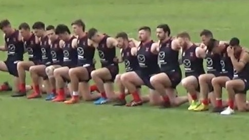 Pooraka Football Club players take a knee during the national anthem before Saturday's division five grand final.