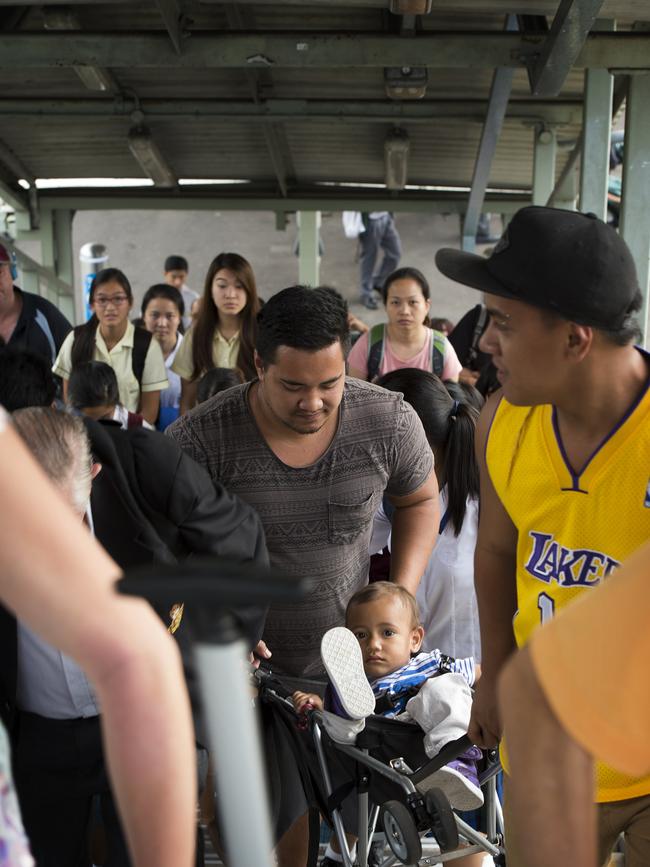 Tama Hewett climbs the stairs at Doonside station, carrying his pram as there are no lifts.