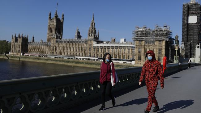 People wear masks as they walk near Britain's Houses of Parliament.