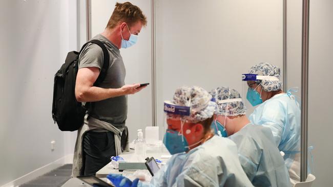 A Brisbane passenger waits for a COVID test at Melbourne Airport on Saturday. Picture: David Crosling