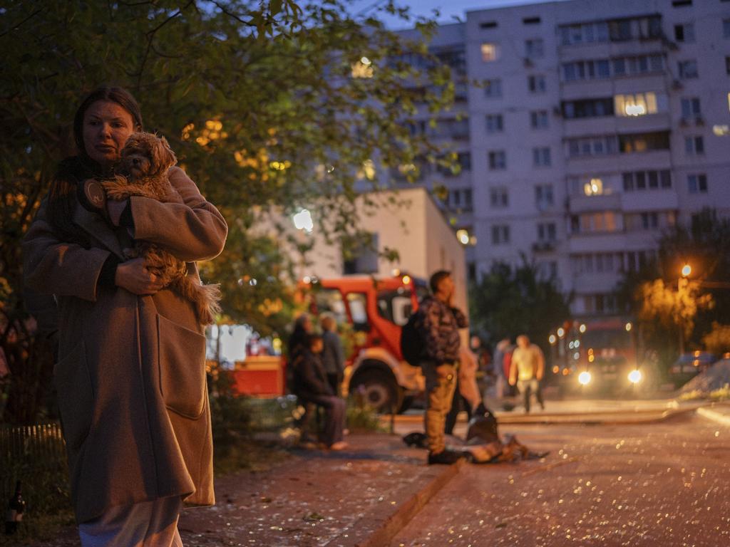 A woman walks amid shattered glass carrying her dog after her apartment building suffered damage in a Russian drone attack. Picture: Alex Babenko / AP