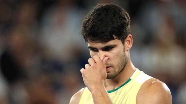 Spain's Carlos Alcaraz reacts as he plays against Germany's Alexander Zverev during their men's singles quarter-final match on day 11 of the Australian Open tennis tournament in Melbourne on January 24, 2024. (Photo by Martin KEEP / AFP) / -- IMAGE RESTRICTED TO EDITORIAL USE - STRICTLY NO COMMERCIAL USE --