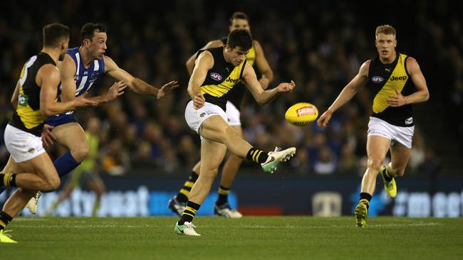 Trent Cotchin launches the Tigers forward against North Melbourne.