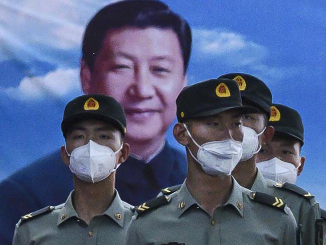 BEIJING, CHINA - MAY 20: Soldiers of the People's Liberation Army's Honour Guard Battalion wear protective masks as they stand at attention in front of photo of China's president Xi Jinping at their barracks outside the Forbidden City, near Tiananmen Square, on May 20, 2020 in Beijing, China. China's government will open its annual weeklong meetings known as the 'two sessions' at the Great Hall of the People on May 21st. They were delayed in March due to the COVID-19 pandemic. After decades of growth, officials recently said China's economy had shrunk in the latest quarter due to the impact of the coronavirus epidemic. The slump in the worlds second largest economy is regarded as a sign of difficult times ahead for the global economy. While industrial sectors in China are showing signs of reviving production, a majority of private companies are operating at only 50% capacity, according to analysts. With the pandemic hitting hard across the world, officially the number of coronavirus cases in China is dwindling, ever since the government imposed sweeping measures to keep the disease from spreading. Officials believe the worst appears to be over in China, though there are concerns of another wave of infections as the government attempts to reboot the worlds second largest economy. Since January, China has recorded more than 82,000 cases of COVID-19 and at least 4000 deaths, mostly in and around the city of Wuhan, in central Hubei province, where the outbreak first started. (Photo by Kevin Frayer/Getty Images)