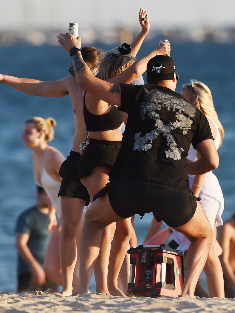 Maskless drinkers dance on the sand at Elwood Beach. Picture: Josie Hayden