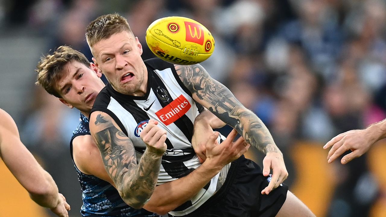 Jordan De Goey handballs while being tackled by Paddy Dow. Picture: Quinn Rooney/Getty Images