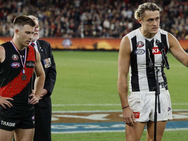 MELBOURNE , AUSTRALIA. April 25, 2024.  AFL.. Anzac Day.  Essendon vs Collingwood at the the MCG. Darcy Moore of the Magpies and Zach Merrett of the Bombers make a joint speech after the match was a draw    . Pic: Michael Klein