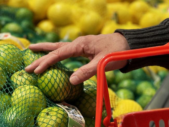 SYDNEY, AUSTRALIA - AUGUST 16: A customer selects limes at a fruit stand in the central business district on August 16, 2022 in Sydney, Australia. According to Australia's Bureau of Statistics, Australia's inflation rate rose to 6.1 in June, a 21-year high. (Photo by Lisa Maree Williams/Getty Images)