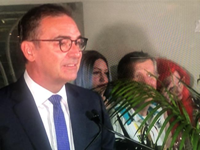 While outgoing Premier Steven Marshall was giving his concession speech, a young red-haired woman who could be seen in the background on the TV broadcast was spotted repeatedly giving a sly middle finger in front of her forehead.