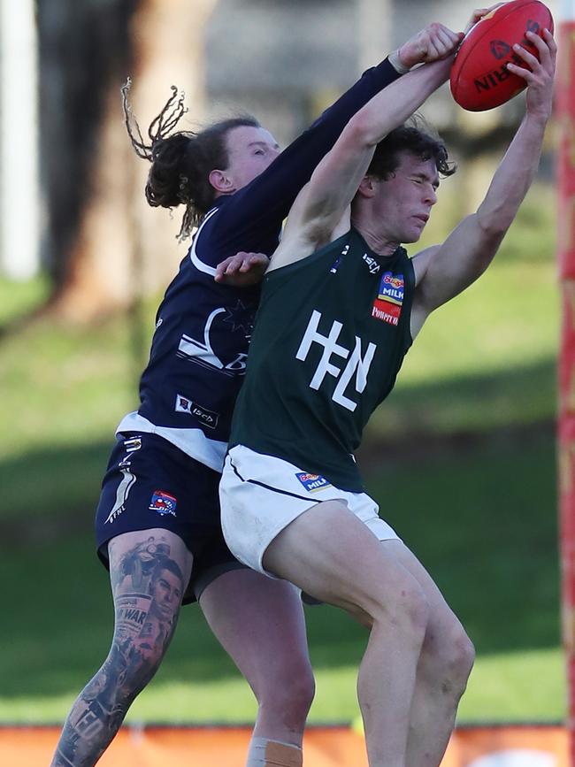 Hampden’s Ryley O’Sullivan takes a mark over Ballarat’s Conrad Farrugia. Picture Yuri Kouzmin