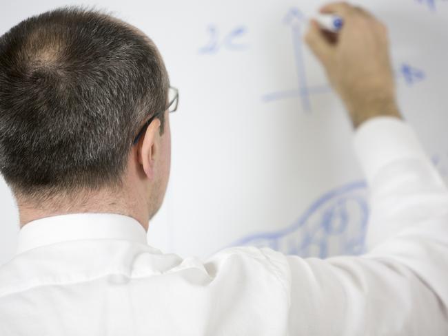 A businessman writes something on whiteboard