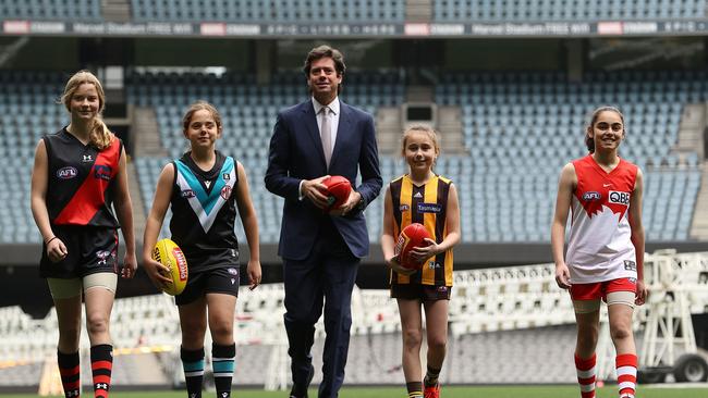 AFL chief executive Gillon Mclachlan poses with young footballers Nora Don, Fadilla Taleb, Leni Burgoyne and Layla Rabah ahead of announcing the expansion of the AFLW to 18 teams Picture: Getty Images