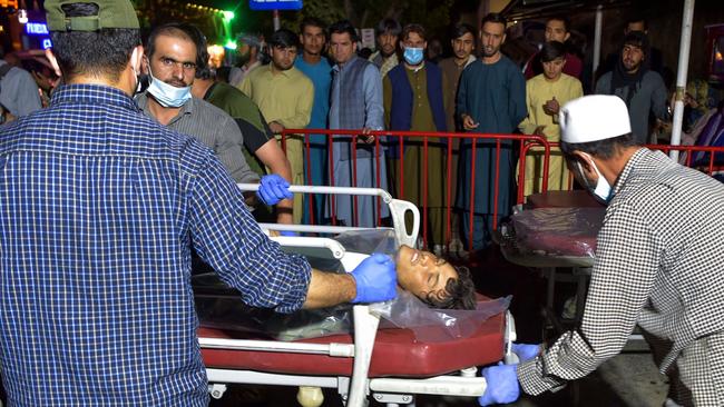 Volunteers and medical staff bring an injured man on a stretcher to a hospital for treatment after two blasts outside the airport in Kabul. Picture: AFP