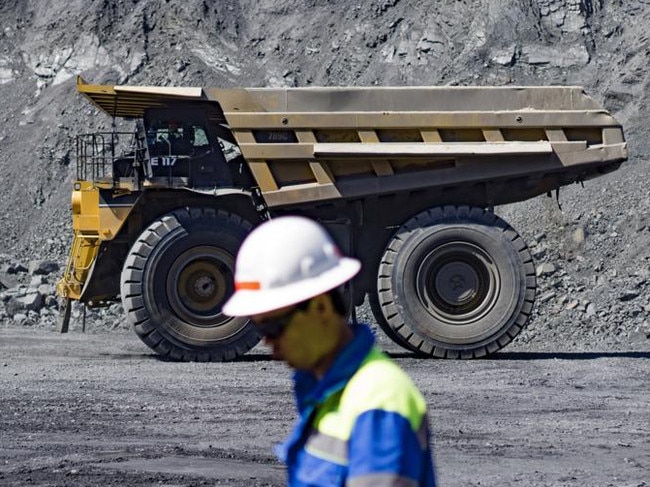 A worker walks by a dump truck carrying freshly excavated ore at the Yeristovo and Poltava iron ore mine, operated by Ferrexpo Poltava Mining PJSC, in Poltava, Ukraine, on Friday, May 5, 2017. China accounted for over 60% of global iron-ore demand in 2016, World Steel Association data show and was Ferrexpo's largest export-sales contributor by country. Photographer: Vincent Mundy/Bloomberg