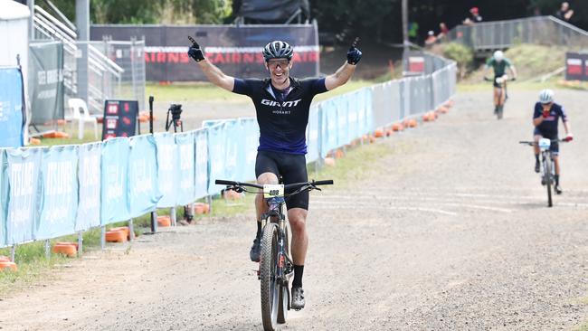 Mark Leis raises his arms in the air as he crosses the finish line to win the Male 50 to 54 years cross country class of the UCI Masters Mountain Bike World Championships, held at Smithfield Mountain Bike Park. Picture: Brendan Radke