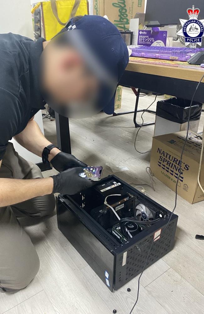 An officer examines a hard drive Picture: Australian Federal Police