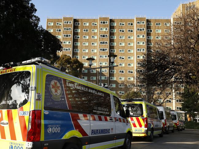 MELBOURNE, AUSTRALIA - JULY 08: A row of Ambulances are seen lined up outside the North Melbourne Public Housing tower complex on July 08, 2020 in Melbourne, Australia. Further lockdown measures for residents in metropolitan Melbourne or the Mitchell shire will come into effect from 11:59 Wednesday 8 July. Under the new lockdown restrictions which will be in place for six weeks, people will only able to leave home have for exercise or work, to buy essential items including food or to access childcare and healthcare. Victorians cannot gather in groups of more than two or their household group, school holidays will be extended for at least a week. Retail can remain open and markets are permitted to open for food and drink only. Cafes, restaurants, pubs, clubs and bars are back to takeaway only. (Photo by Darrian Traynor/Getty Images)