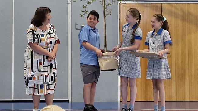 Riverside Primary School leaders Jack Pierce, Cassidy Gibson and Holly Bennett presenting retiring principal Jane Bovill with her farewell gift. Picture: Supplied