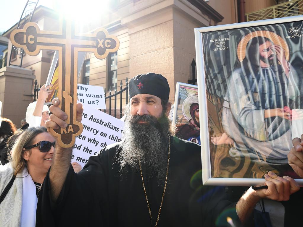 Anti-abortion advocates hold placards during a rally outside the New South Wales Parliament house in Sydney, Tuesday, August 6, 2019. (AAP Image/Joel Carrett)