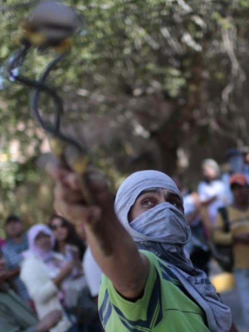 A teacher throws stones at the building of the lawyer of the Mexican state of Guerrero, during a protest a year after the disappearance of 43 students. Picture: AFP