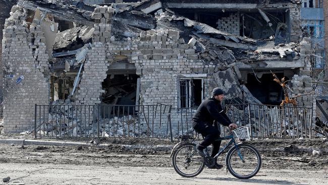 A local resident rides a bicycle past a building destroyed during Ukraine-Russia conflict in the separatist-controlled town of Volnovakha in the Donetsk region. Picures: Reuters